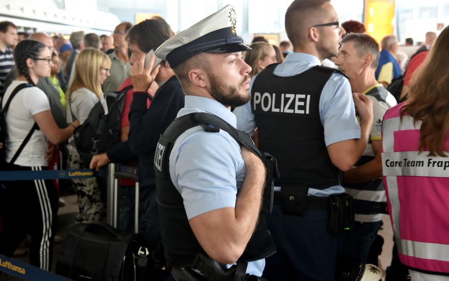 Police and passengers stand in the departure area at Frankfurt airport, central Germany, Wednesday, Aug31, 2016. (Frank Rumpenhorst/dpa via AP) ** FILE **