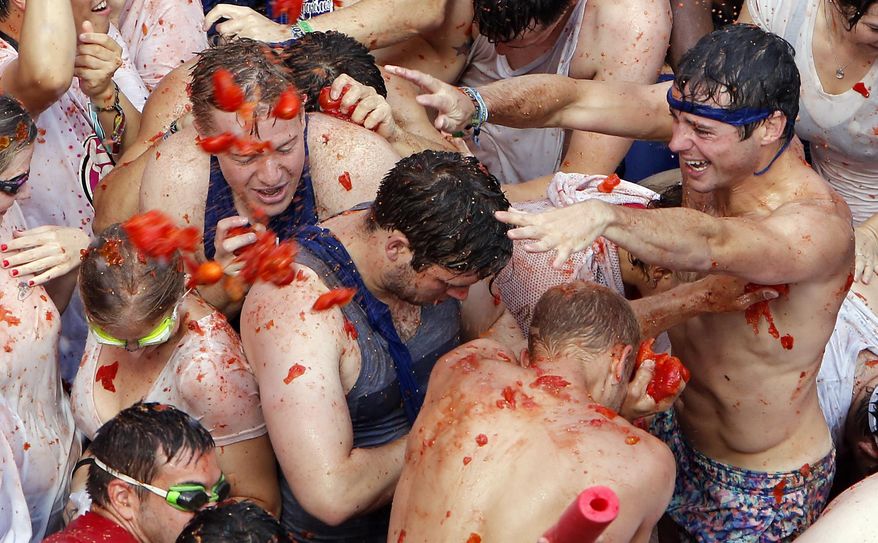 Crowds of people throw tomatoes at each other, during the annual "Tomatina", tomato fight fiesta, in the village of Bunol, 50 kilometers outside Valencia, Spain, Wednesday, Aug. 31, 2016. (AP Photo/Alberto Saiz)