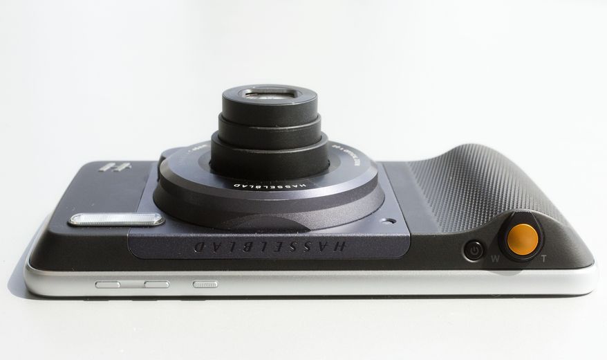 Motorola's Moto Z phone, with the Hasselblad True Zoom attachment, is viewed from the top side, Wednesday, Aug. 31, 2016, in New York. The orange camera shutter button is at right. Motorola says the attachment will appeal mostly to photography aficionados, but the company believes that's a sizable market. (AP Photo/Mark Lennihan)