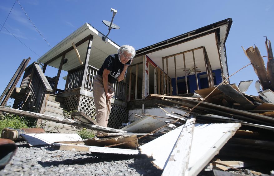 Mayor Andrea "Andy" Pendleton, looks through debris from a flood ravaged home in Rainelle, W.Va., on Tuesday, Aug. 23, 2016. The town of 1,500 was badly battered during the late June floods that killed 23 people statewide. (AP Photo/Steve Helber)