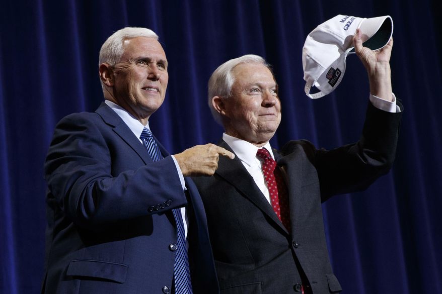 Republican vice presidential candidate Gov. Mike Pence, R-Ind., left, stands with Sen. Jeff Sessions, R-Ala., as he holds up a hat that says "Make Mexico Great Again Also" during a campaign event with Republican presidential candidate Donald Trump at the Phoenix Convention Center, Wednesday, Aug. 31, 2016, in Phoenix. (AP Photo/Evan Vucci)
