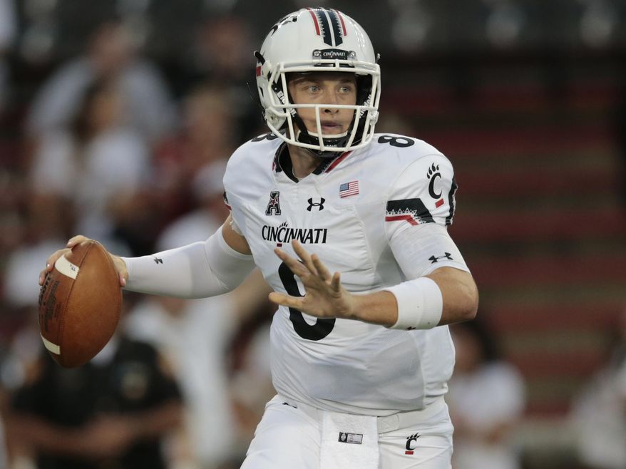 Cincinnati quarterback Hayden Moore (8) rolls out of the pocket and looks to throw during the first half of an NCAA college football game against Tennessee-Martin, Thursday, Sept. 1, 2016, at Nippert Stadium in Cincinnati. (Kareem Elgazzar/The Cincinnati Enquirer via AP)