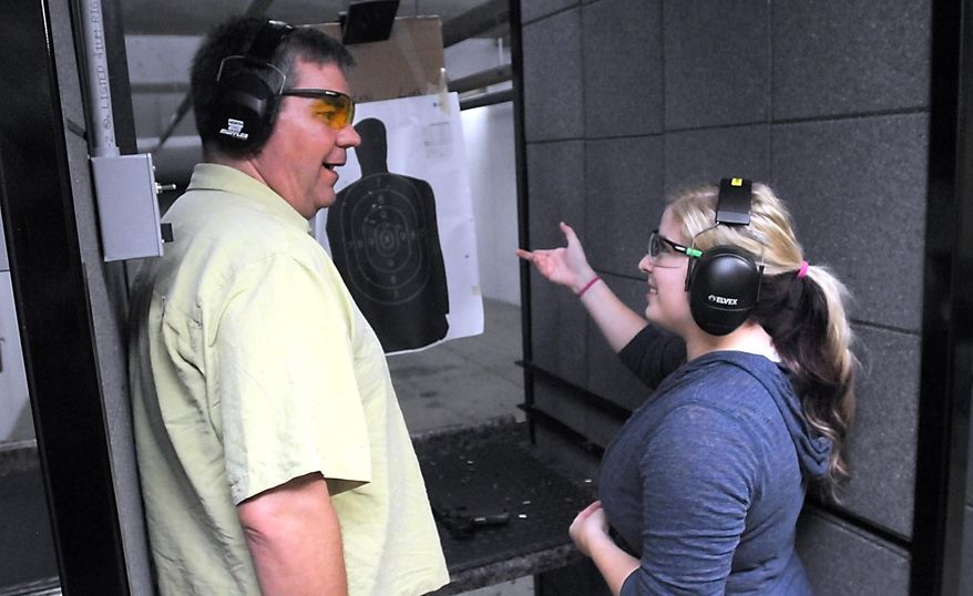In this Saturday, Aug. 27, 2016 photo, conceal and carry instructor Tobias Leonard talks with student Allyson Hlavka after her turn shooting at Saat Vantage Point Shooting Range in Kasota, Minn. (Pat Christman/The Free Press via AP)
