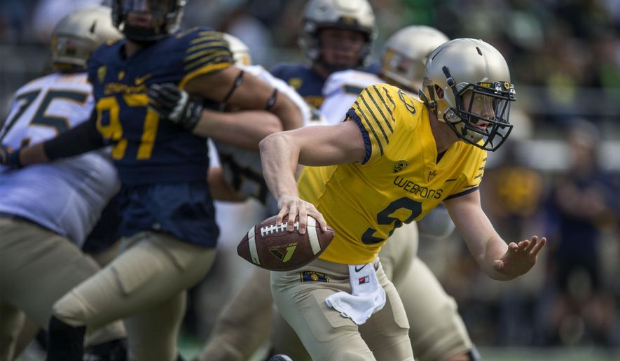 FILE - In this April 30, 2016, file photo, quarterback Dakota Prukop scrambles with the football during the Oregon Spring Game in Eugene, Ore. Prukop will be the face of the new-look Oregon Saturday, Sept. 3, 2016, when the team hosts UC Davis in the season opener.. (Andy Nelson /The Register-Guard via AP, File)