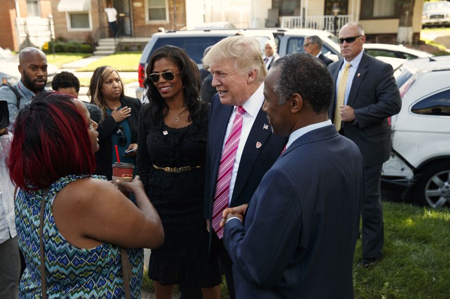 Neighborhood resident Felicia Reese, left, talks with Republican presidential candidate Donald Trump and Dr. Ben Carson, during a tour of Carson&#39;s childhood home, Saturday, Sept. 3, 2016, in Detroit. (AP Photo/Evan Vucci)