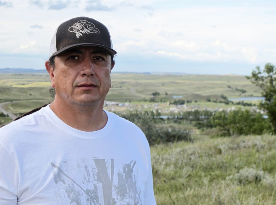 In this Aug. 26, 2016, photo, Standing Rock Sioux Chairman Dave Archambault II poses for a photo near Cannon Ball., N.D., on the Standing Rock Sioux Reservation overlooking an encampment where Native Americans from across North America have gathered to join his tribe's growing protest against a $3.8 billion four-state oil pipeline. About 30 people, including Archambault himself, have been arrested in recent weeks for interfering with construction of the Dakota Access pipeline. (AP Photo/James MacPherson) ** FILE **