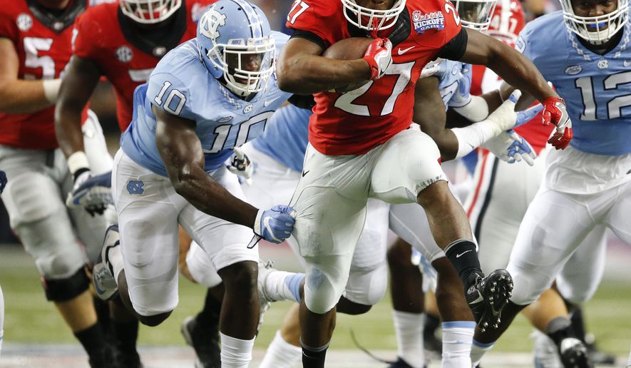 Georgia running back Nick Chubb (27) tries to breaks away from North Carolina linebacker Andre Smith (10) in the first of an NCAA college football game against North Carolina in Atlanta, Saturday, Sept. 3, 2016. Chubb missed most of last season with a knee injury. (AP Photo/John Bazemore)