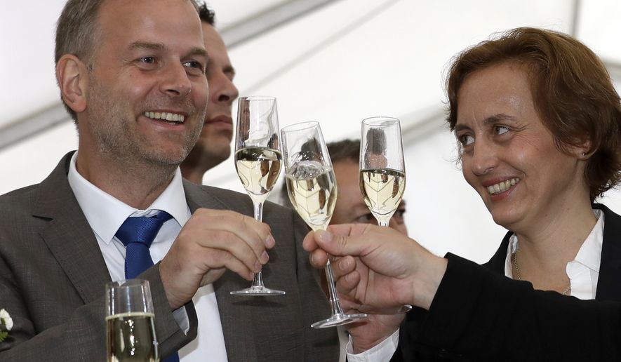 AfD member Beatrix von Storch, right, and Leif-Erik Holm, left, top candidate of the AfD, toast at the gathering of AfD (Alternative for Germany) party in Schwerin, Germany, Sunday, Sept. 4, 2016 after the closing of the state elections in the German federal state of Mecklenburg-Western Pomerania.  Exit polls indicate that the  nationalist, anti-immigration party has performed strongly in a state election in the region where Chancellor Angela Merkel has her political base, likely overtaking her conservative party. (AP Photo/Michael Sohn)
