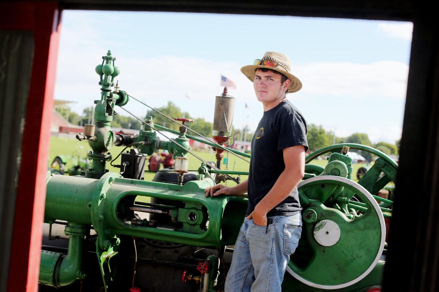 ADVANCE FOR SUNDAY SEPT. 4 AND THEREAFTER - In a Wednesday Aug. 24, 2016 photo, Jacob Nelson, of Lockridge, Iowa, poses for a photo with his 1917-50 hp Case steam engine, at the Midwest Old Threshers grounds in Mount Pleasant, Iowa. Nelson, 20, is a lifelong steam engine aficionado. Nelson's love for steam engines comes from his father, Rob, and he's spent much of his life not only figuring out how the engines work but how to fix them. (John Lovretta/The Hawk Eye via AP)