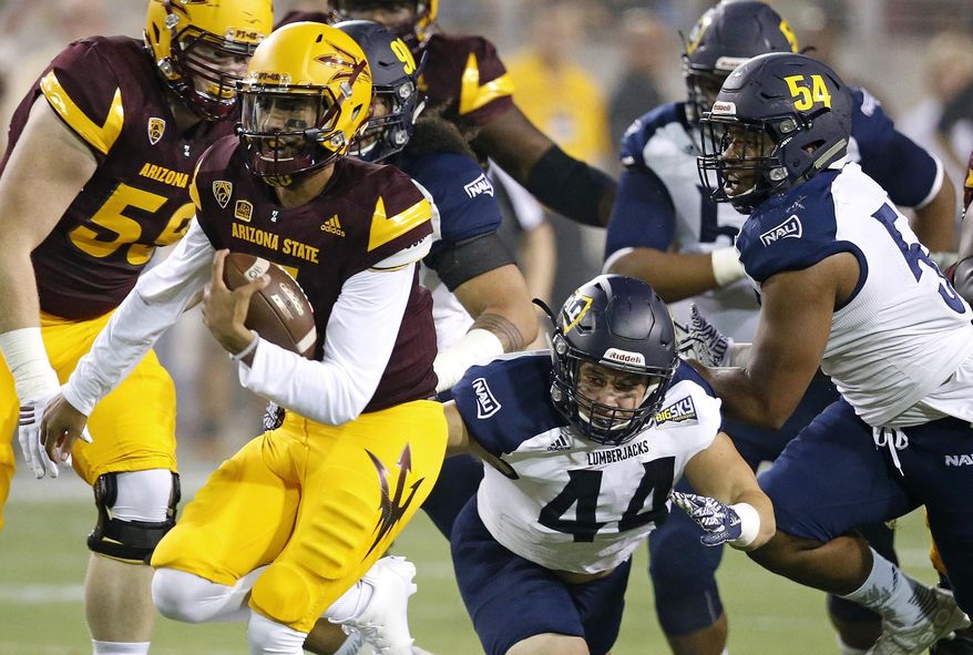 Arizona State's Manny Wilkins, left, runs past Northern Arizona's Jake Thomas (44) and Lorenzo Melvin (54) for a first down during the first half of an NCAA college football game Saturday, Sept. 3, 2016, in Tempe, Ariz. (AP Photo/Ross D. Franklin)