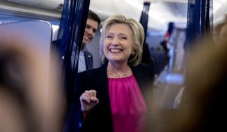Democratic presidential candidate Hillary Clinton, accompanied by Traveling Press Secretary Nick Merrill, left, smiles as she speaks to members of the media as her campaign plane prepares to take off at Westchester County Airport in Westchester, N.Y., Tuesday, Sept. 6, 2016, to head to Tampa for a rally in Tampa. (AP Photo/Andrew Harnik)