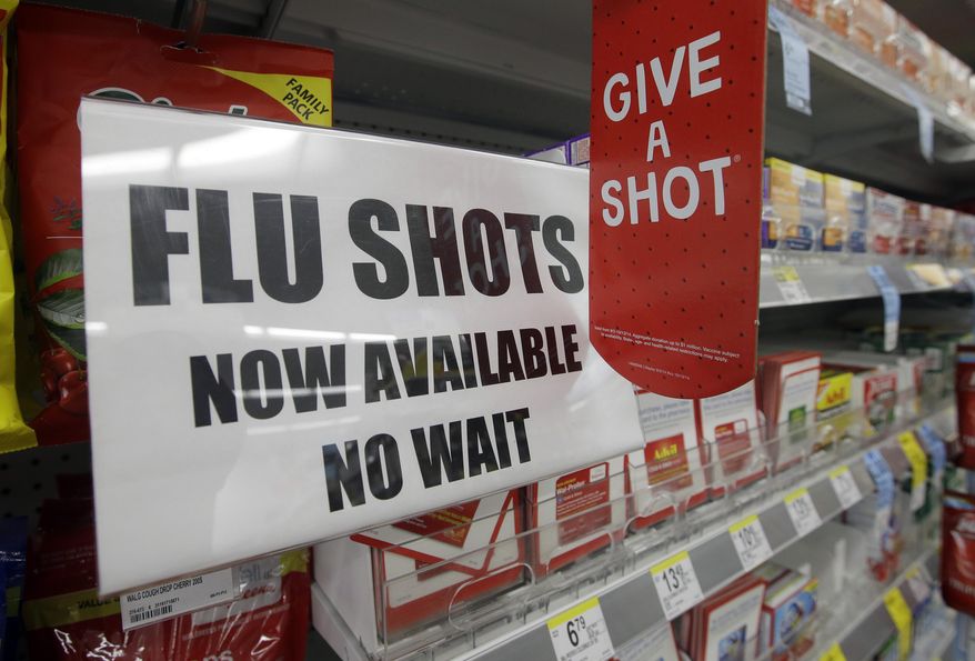 A sign telling customers that they can get a flu shot in a Walgreens store is seen in Indianapolis on Sept. 16, 2014. (Associated Press) **FILE**