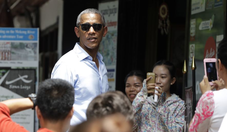 People take photos of U.S. President Barack Obama as he tours a shopping area near the Mekong River in the Luang Prabang, Laos, Wednesday, Sept. 7, 2016. (AP Photo/Carolyn Kaster)