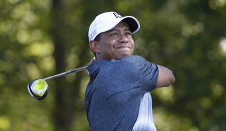 In this July 31, 2015, file photo, Tiger Woods watches his tee shot on the 13th hole during the second round of the Quicken Loans National golf tournament, in Gainesville, Va. (AP Photo/Steve Helber, File)