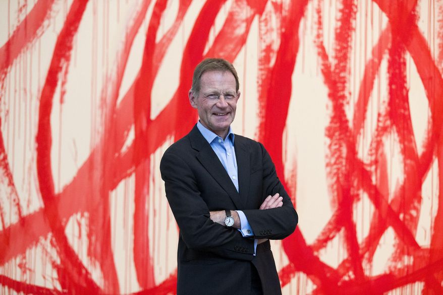 FILE - This is a June 11, 2014 file photo of Sir Nicholas Serota in front of "Untitled (Bacchus) 2006-2008, Acrylic on canvas", by Cy Twombly. Britain's Tate group of art galleries said Thursday Sept. 8, 2016, that director Nicholas Serota is stepping down after 28 years in charge. The government says Serota has been appointed chairman of Arts Council England, which distributes money to cultural organizations, starting in February 2017. (Justin Tallis/PA via AP)