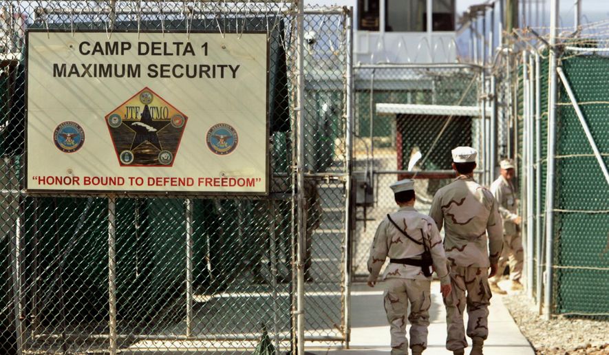 FILE - In this June 27, 2006 file photo, reviewed by a Defense Department, U.S. military guards walk within Camp Delta military-run prison, at the Guantanamo Bay U.S. Naval Base, Cuba. A federal appeals court expressed concerns on Thursday, Sept. 8, 2016, about the prospect of ordering the Obama administration to release graphic videos of a former Guantanamo Bay inmate being force-fed during a hunger strike.  (AP Photo/Brennan Linsley, File)