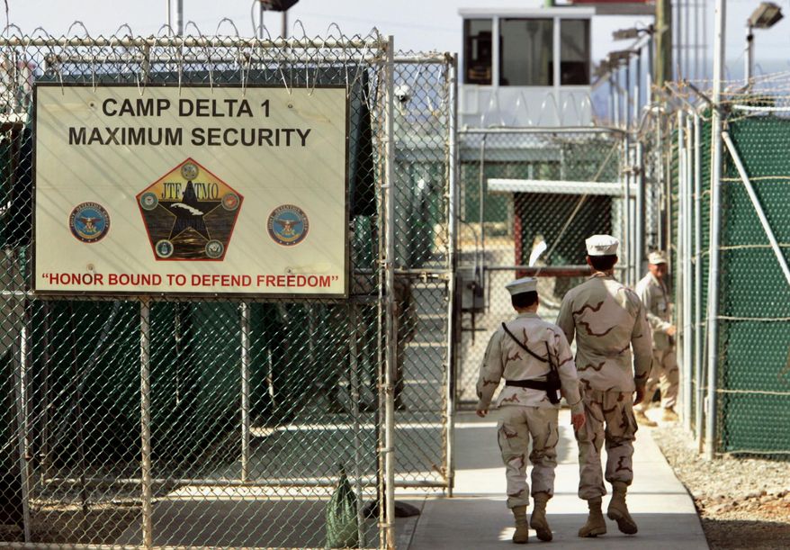 FILE - In this June 27, 2006 file photo, reviewed by a Defense Department, U.S. military guards walk within Camp Delta military-run prison, at the Guantanamo Bay U.S. Naval Base, Cuba. A federal appeals court expressed concerns on Thursday, Sept. 8, 2016, about the prospect of ordering the Obama administration to release graphic videos of a former Guantanamo Bay inmate being force-fed during a hunger strike. (AP Photo/Brennan Linsley, File)