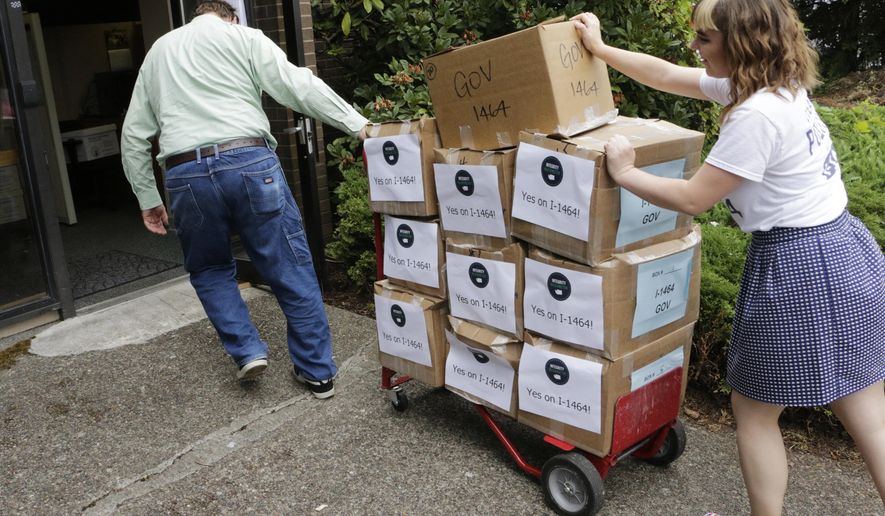 FILE - In this July 8, 2016, file photo, supporters of a proposed campaign finance reform ballot measure arrive to turn in boxes of signed petitions in Olympia, Wash. Washington voters will soon decide whether or not to make the most sweeping changes to the state's campaign finance system in decades. (AP Photo/Rachel La Corte, File)