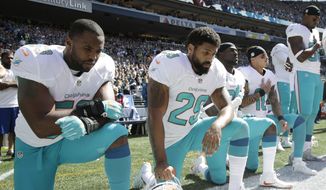 From left, Miami Dolphins&#39; Jelani Jenkins, Arian Foster, Michael Thomas, and Kenny Stills, kneel during the singing of the national anthem before an NFL football game against the Seattle Seahawks, Sunday, Sept. 11, 2016, in Seattle. (AP Photo/Stephen Brashear)