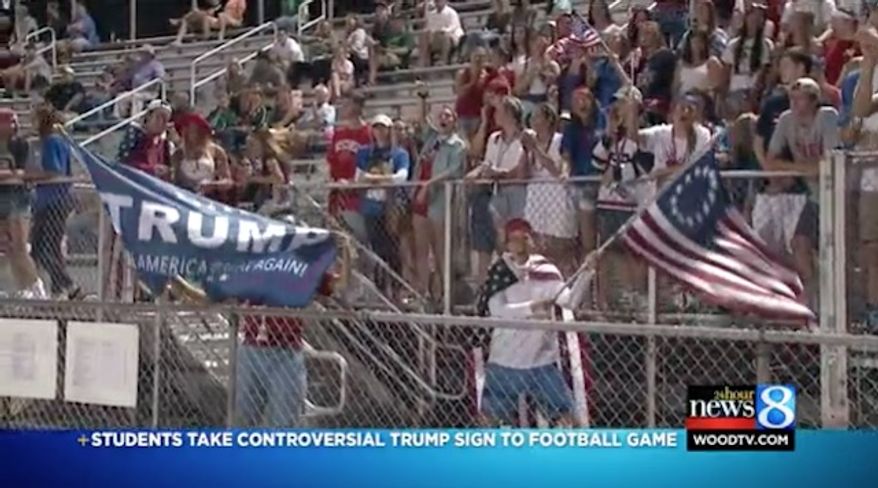 Several high school students who waved a Donald Trump flag and a "Betsy Ross" 13-star flag at an inner city Grand Rapids football game Friday night are being criticized as racist. (WOOD-TV)