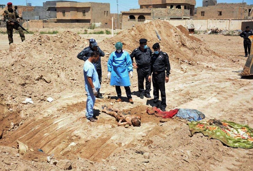 An Iraqi security forces forensic team works at the site of a mass grave believed to contain the bodies of Iraqi civilians, security forces and members of their families, including women and children, killed by Islamic State group militants in Ramadi, Iraq. (Associated Press)