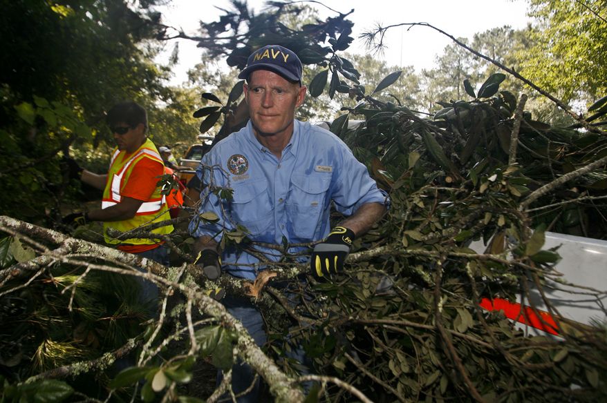 Florida Gov. Rick Scott picks up fallen branches to put into the back of a truck Wednesday, Sept. 7, 2016 during a debris cleanup from Hurricane Hermine in Indian Head Acres in Tallahassee, Fla. (AP Photo/Phil Sears)