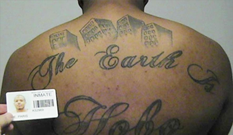 This undated photo in a court filing provided by the United States Attorney's office in Chicago, shows Paris Poe's back tattoo that reads 'The Earth Is Our Turf, and Hobo. Poe is one of six defendants on trial for racketeering and other charges are purported leaders of the widely feared Hobos, a South Side gang that federal prosecutors say murdered, maimed and tortured their way into control of some of Chicago's most lucrative drug markets. Their federal trial begins Wednesday, Sept. 14, 2016 with opening statements in Chicago. (United States Attorney's office in Chicago via AP)