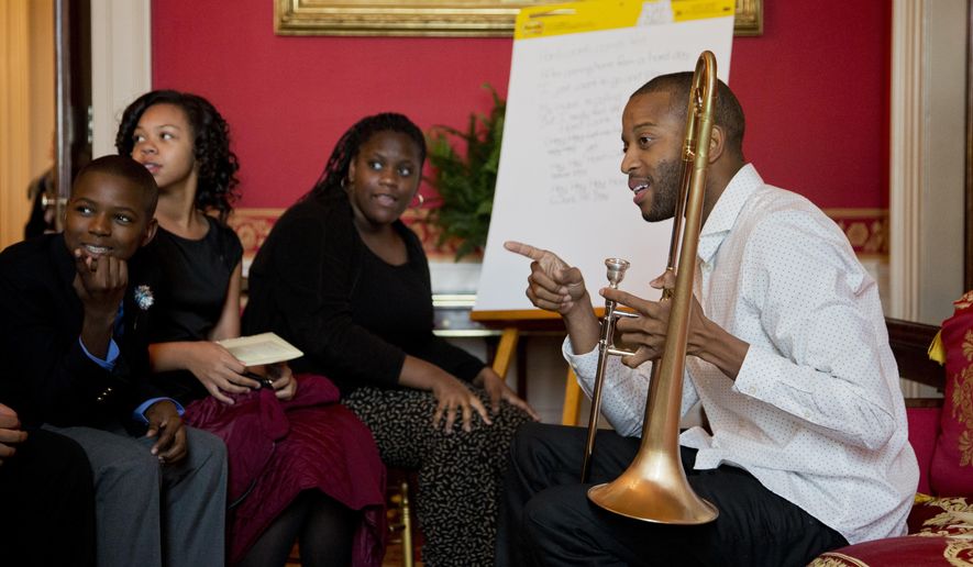 FILE - In this Oct. 14, 2015, file photo, musician Troy "Trombone Shorty" Andrews, right, of New Orleans mentors middle school children from the Washington area during a student workshop in the Red Room of the White House in Washington. The Heinz Family Foundation announced winners of the Heinz Awards on Wednesday, Sept. 14, 2016, naming musician Troy "Trombone Shorty" Andrews and others as winners. (AP Photo/Manuel Balce Ceneta, File)