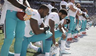 Kneeling from left, Miami Dolphins&#39; Jelani Jenkins, Arian Foster, Michael Thomas, and Kenny Stills, kneel during the singing of the national anthem before an NFL football game against the Seattle Seahawks, Sunday, Sept. 11, 2016, in Seattle. (AP Photo/Stephen Brashear)