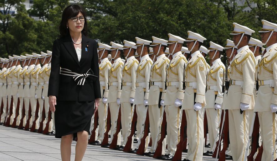 FILE - In this Aug. 4, 2016 file photo, Japan's new Defense Minister Tomomi Inada inspects a honor guard on her first day at the Defense Ministry in Tokyo. Inada, who holds her first meeting with U.S. counterpart Ash Carter on Thursday, Sept. 15, in Washington, D.C., leapfrogged over more senior lawmakers to the defense post in a Cabinet reshuffle on Aug. 3. The 57-year-old lawyer has attracted attention for questioning mainstream accounts of Japanese atrocities during World War II and the fairness of the postwar Tokyo war crimes trials. (AP Photo/Shuji Kajiyama, File) **FILE**