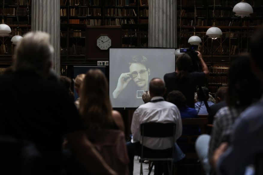 National Security Agency leaker Edward Snowden speaks via video link during the Athens Democracy Forum, organised by the New York Times, at the National Library in Athens, Friday, Sept. 16, 2016. Snowden, in exile in Moscow after leaking U.S. National Security Agency documents, said Friday he intends to vote in the U.S. presidential election, but did not say which candidate he favors. (Kostas Baltas, InTime Sports via AP)