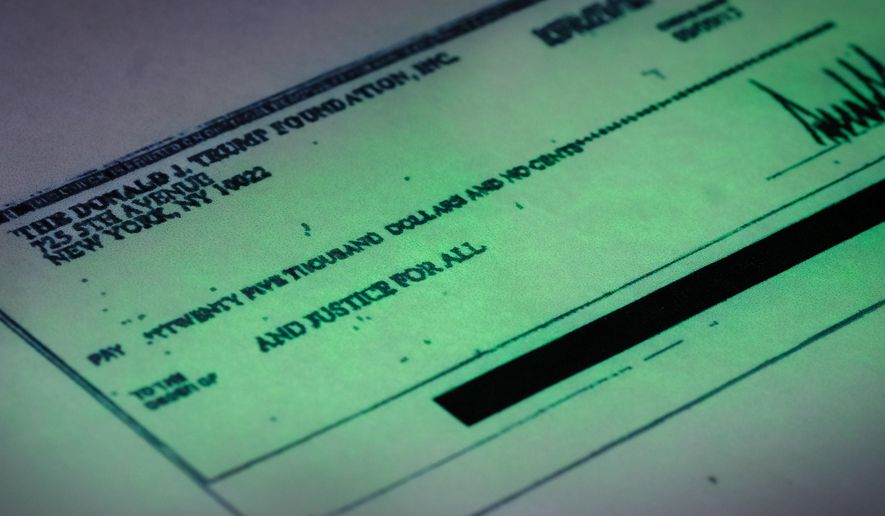 This photo made in the Associated Press Washington bureau on Thursday, Sept. 15, 2016 shows a copy of a check provided by the New York state attorney general that shows a payment of $25,000 from the Donald J. Trump Foundation to And Justice For All signed by Donald J. Trump. The $25,000 check was sent from his personal foundation to a political committee supporting Florida Attorney General Pam Bondi. Charities are barred from engaging in political activities. Trump’s campaign contends that the 2013 check from the Trump Foundation was mistakenly issued following a series of clerical errors and that Trump intended to use personal funds. (AP Photo/J. David Ake)