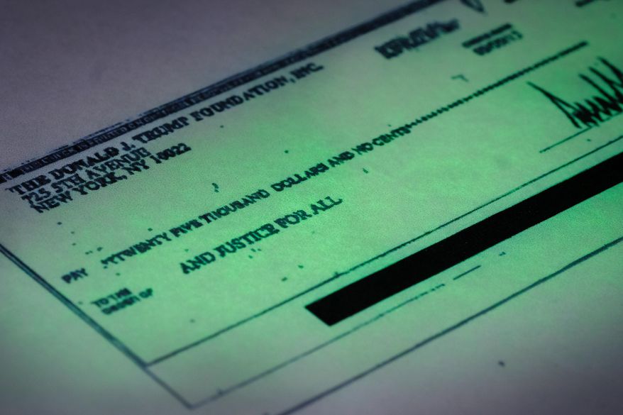 This photo made in the Associated Press Washington bureau on Thursday, Sept. 15, 2016 shows a copy of a check provided by the New York state attorney general that shows a payment of $25,000 from the Donald J. Trump Foundation to And Justice For All signed by Donald J. Trump. The $25,000 check was sent from his personal foundation to a political committee supporting Florida Attorney General Pam Bondi. Charities are barred from engaging in political activities. Trump’s campaign contends that the 2013 check from the Trump Foundation was mistakenly issued following a series of clerical errors and that Trump intended to use personal funds. (AP Photo/J. David Ake)