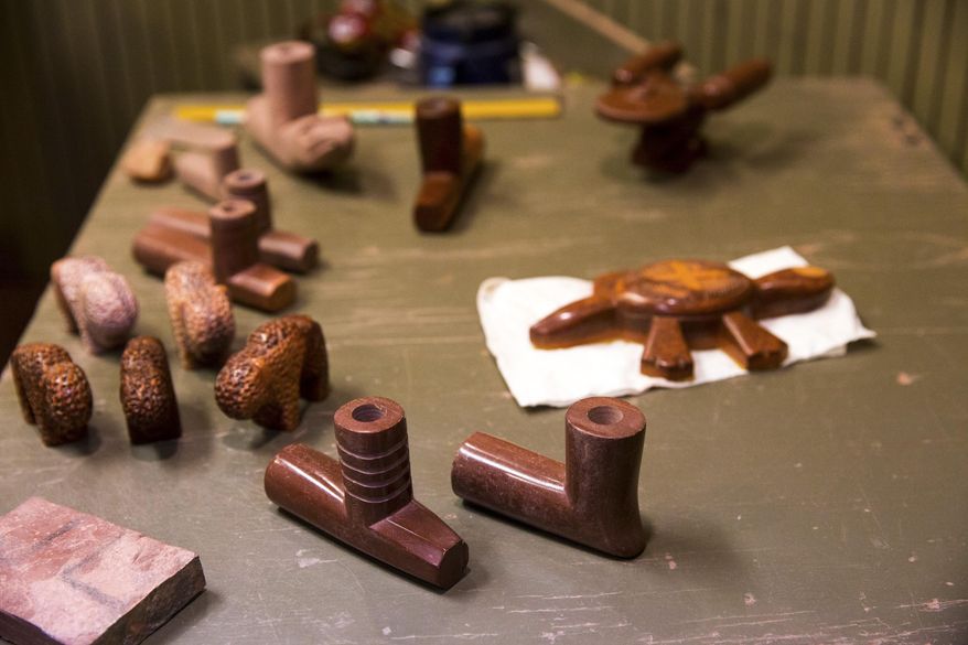ADVANCE FOR WEEKEND EDITIONS SEPT 17-18 - In this Wednesday, Aug. 24, 2016 photo, pipes and stone carvings made by Travis Redwing sit on a table next to his carving station in the visitors center at Pipestone National Monument in Pipestone, Minn. Redwing is one of multiple cultural demonstrators visitors can watch carving the pipes and stems. (Evan Frost/Minnesota Public Radio via AP)