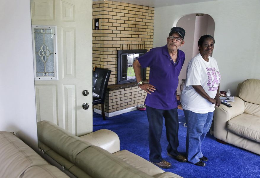 ADVANCE FOR USE SATURDAY, SEPT. 17, 2016 AND THEREAFTER - In this Aug. 19, 2016 photo, A.C. and Janice Love admire the interior of their home in Lockport, Ill. Volunteers recently applied a fresh coat of paint to the interior walls and the cinder-block exterior of the Loves' home through the Fairmont Redevelopment Program. With the help of a combined $1 million between two U.S. Department of Housing and Urban Development grants, the program helping neighborhood residents revive the area. (Eric Ginnard/Herald-News via AP)