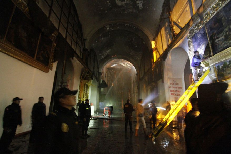 Firefighters and police inspect the famed 16th century San Sebastian church after it was partially destroyed by fire in Cuzco, Peru, Friday, Sept. 16, 2016. The blaze that burned into Friday morning destroyed the ornate, gilded altar and about two dozen paintings at the Temple of San Sebastian. (AP Photo/Percy Hurtado)
