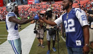 Dallas Cowboys wide receiver Dez Bryant (88) greets Washington Wizards point guard John Wall before an NFL football game against the Washington Redskins in Landover, Md., Sunday, Sept. 18, 2016. (AP Photo/Alex Brandon)