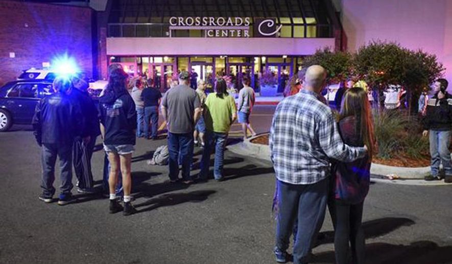 People stand near the entrance on the north side of Crossroads Center mall between Macy's and Target as officials investigate a reported multiple stabbing incident, Saturday, Sept. 17, 2016, in St. Cloud, Minn. Police said multiple people were injured at the St. Cloud shopping mall on Saturday evening in an attack possibly involving both shooting and stabbing. The suspect is believed to be dead, St. Cloud Police Sgt. Jason Burke told the St. Cloud Times. (Dave Schwarz/St. Cloud Times via AP)