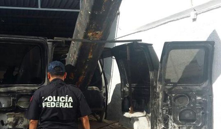 In this Sept. 17, 2016 photo released by Mexico Federal Police, an officer stands next to a van outfitted with a 10-foot (3-meter) air cannon in Agua Prieta, Mexico, along the border with Douglas, Arizona. According to federal police, it was used to shoot projectiles into the U.S. and the van was reported stolen from the city of Hermosillo in the Mexican state of Sonora over the summer. a U.S. Border Patrol spokesman said that the most common common use for this sort of device is lobbying marijuana packages over the border fence. (AP Photo/Policia Federal Preventiva)