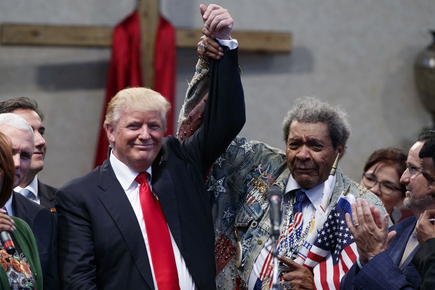 Boxing promoter Don King holds up the hand of Republican presidential candidate Donald Trump during a visit to the Pastors Leadership Conference at New Spirit Revival Center, Wednesday, Sept. 21, 2016, in Cleveland, Ohio. (AP Photo/ Evan Vucci)