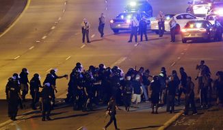 Police confront protesters blocking I-277 during a third night of unrest following Tuesday&#x27;s police shooting of Keith Lamont Scott in Charlotte, N.C., Thursday, Sept. 22, 2016. (AP Photo/Gerry Broome)
