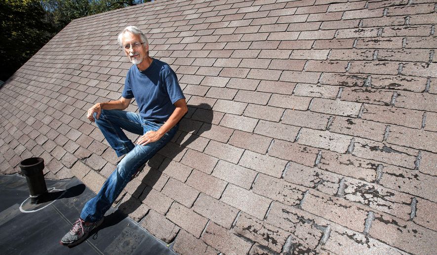 ADVANCE FOR USE SATURDAY, SEPT. 24, 2016 AND THEREAFTER - In this Sept. 12, 2016 photo, Urbana alderman Dennis Roberts sits on the roof of his home in Urbana, Ill. He is one of dozens of people he knows of locally who had home insurers tell them they would have to put new roofs on their homes when they weren't needed yet, and without much time to get the job done, or their coverage would be cancelled. (Rick Danzl/The News-Gazette via AP )