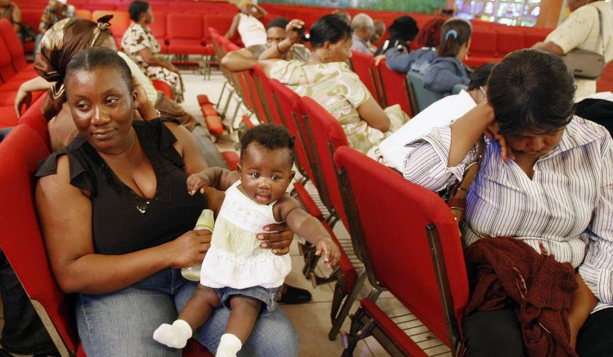 FILE - In this Thursday, Jan. 21, 2010, file photo, Haitian national Carole Manigat, left, holds her daughter Hadassa Carole Albert as she waits for her turn to fill out temporary protective status papers at Notre Dame d&#39;Haiti Catholic Church in the Little Haiti neighborhood in Miami. The U.S. Department of Homeland Security said Thursday, Sept. 22, 2016, that it was widening efforts to deport Haitians, a response to thousands of immigrants from the Caribbean nation who have overwhelmed California border crossings with Mexico in recent months. The move lifts special protections that shielded Haitians from deportation after their nation’s 2010 earthquake. (AP Photo/Alan Diaz, File)