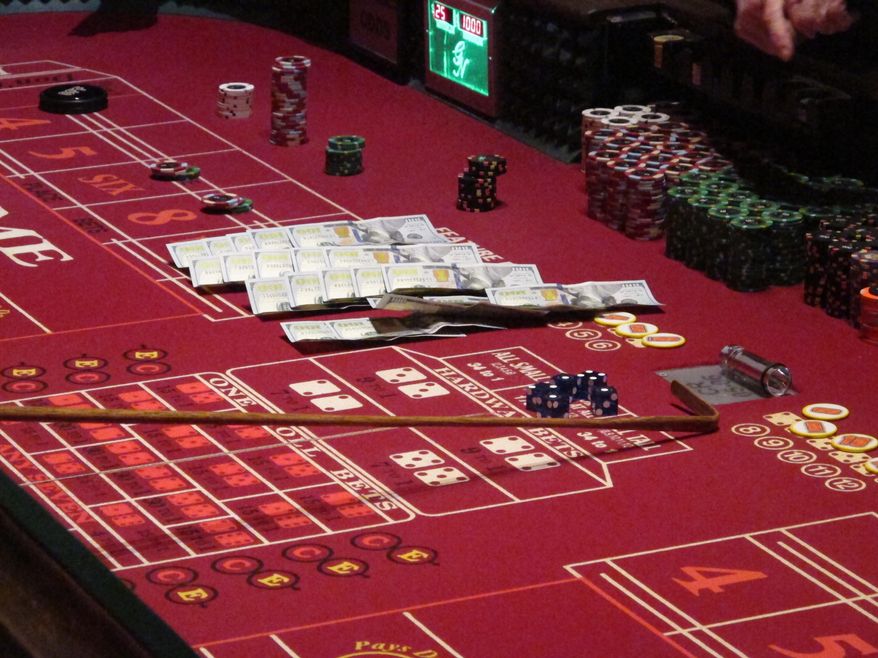 This June 24, 2016, photo shows cash, chips and dice on a craps table during a game at the Golden Nugget casino in Atlantic City, N.J. On Thursday, Sept. 22, 2016, the men who are proposing to build two new casinos in northern New Jersey near New York City, concluded the statewide ballot question that would authorize the projects will not pass, and ended their financial support for a campaign in its favor. (AP Photo/Wayne Parry)