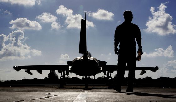 In this Thursday, Sept. 22, 2016, photo, a British soldier walks by a Typhoon aircraft before take off for a mission in Iraq, at  RAF Akrotiri, near the southern coastal city of Limassol, in Cyprus.  British Tornado and Typhoon aircraft stationed at a U.K. air base in Cyprus are pounding Islamic State targets ahead of a major offensive by Iraqi security forces next month to recapture the key northern city of Mosul from IS militants, a senior Royal Air Force officer says. (AP Photo/Petros Karadjias, Pool) **FILE**