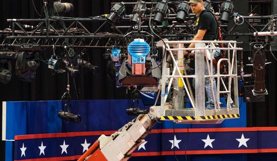 A technician examines the lighting grid as preparations continue for Monday&#x27;s first debate presidential between Democratic Hillary Clinton and Republican Donald Trump, Saturday, Sept. 24, 2016, at Hofstra University in Hempstead, N.Y.  (AP Photo/J. David Ake)