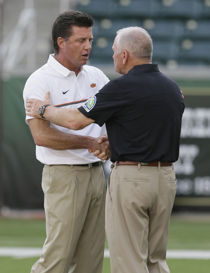Oklahoma State head coach Mike Gundy, left, shakes hands with Baylor acting head coach Jim Grobe before an NCAA college football game Saturday, Sept. 24, 2016, in Waco, Texas. (AP Photo/LM Otero)