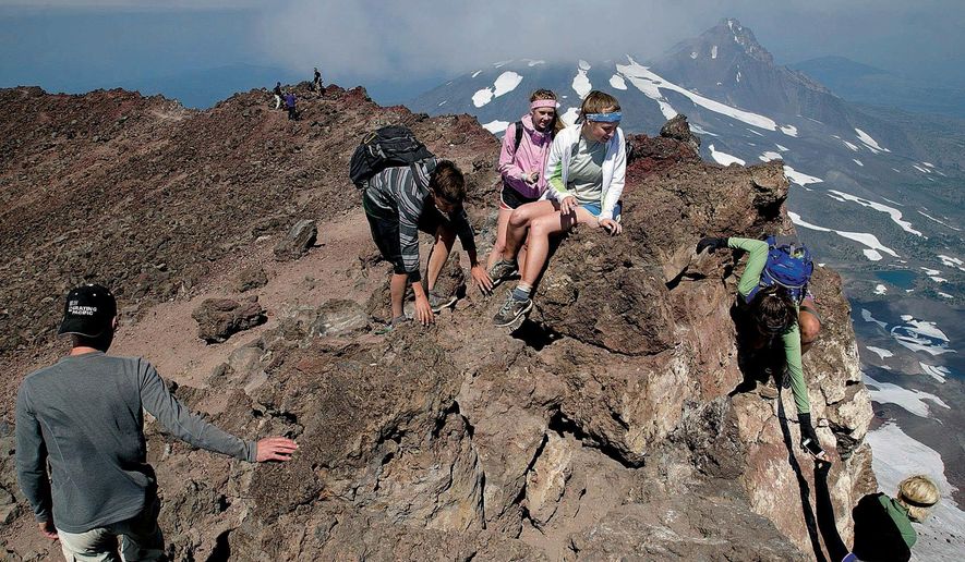 In this 2012 photo, from left, Shawn Foster, Carson Pemble, Emily Read, Brittany Pemble and Megan Pemble explore the summit of South Sister, west of Bend, Ore. Officials with the Deschutes National Forest and the Willamette National Forest are considering changes to possibly limit use in the most popular areas of the Three Sisters Wilderness are in order to maintain the wilderness character of those locations. (Joe Kline /The Bulletin via AP)