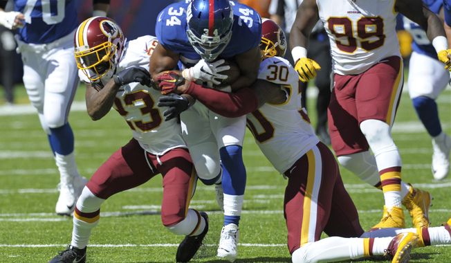 New York Giants running back Shane Vereen (34) is tackled by Washington Redskins&#x27; David Bruton (30) and DeAngelo Hall (23) during the first half of an NFL football game Sunday, Sept. 25, 2016, in East Rutherford, N.J.  (AP Photo/Bill Kostroun)