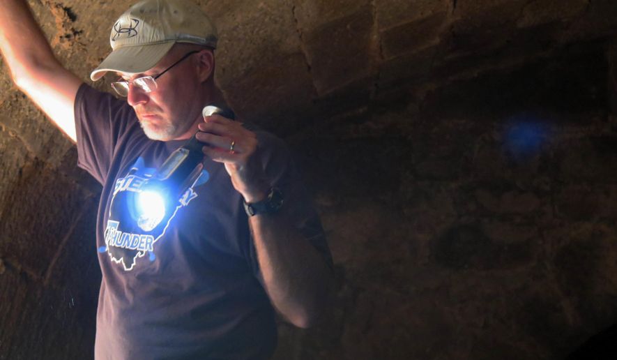 In this Thursday, Sept. 1, 2016 photo, Chuck Foster, a Wheeling Island property owner, shines a flashlight inside his historic wine cellar in Wheeling, W.Va. (Alec Berry/The Intelligencer/Wheeling News-Register via AP)